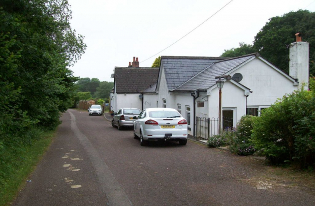 The station once fronted the B3227 but has now been bypassed. The old road narrows to a footpath behind the camera, from where the mouth of Venn Cross Tunnel can just be seen. Devon & Somerset Railway