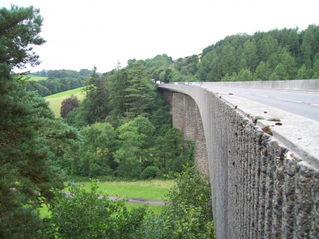 Unseen by the myopic motorist are the slender masonry piers which carried the single line of rails of the Barnstaple Branch across the Bray Valley. The river is amongst the trees beyond the track. Between them was M.P. 200. Devon & Somerset Railway