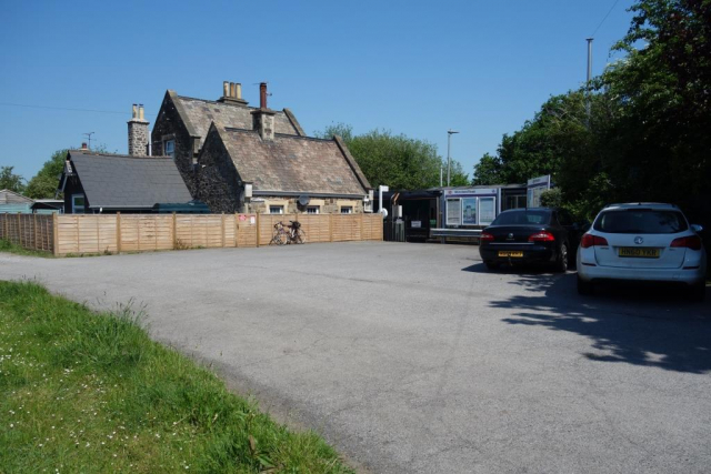 The frontage in May, 2026, with a train about to stop. The lone passenger had driven here, removed the magnetic "L" plates and handed them to his father. Morchard Road Station